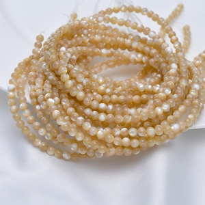 Makroaufnahme von 4mm natürlichen weißen Muschelperlen mit Perlmuttglanz auf Seide