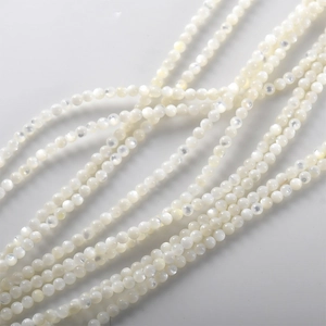 Makro-Detail von 4mm weißen Perlmuttwulsten mit irisierendem Glanz für DIY-Schmuck
