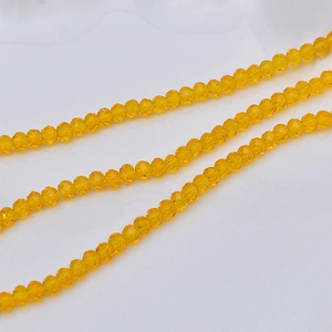 Macro shot of 4mm multi-faceted amber yellow crystal glass beads for DIY jewelry