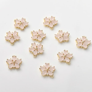 Detail of 14k gold-plated cherry blossom pendants with pink petals for jewelry making
