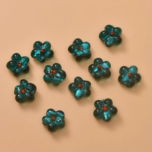 Detailed macro of dark green glaze flower beads with glitter foil for DIY jewelry making