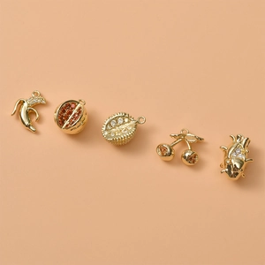 Macro detail of 14K gold plated fruit charms with micro-set cubic zirconia for DIY jewelry