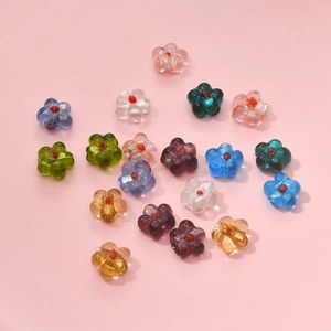 Macro shot of colorful glass flower beads for DIY jewelry with delicate red center details