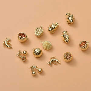Detailed close-up of 14K gold plated fruit charms with tiny zircon stones for DIY jewelry
