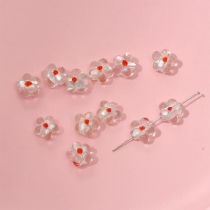 Macro detail of transparent glass flower beads with orange centers for DIY jewelry making
