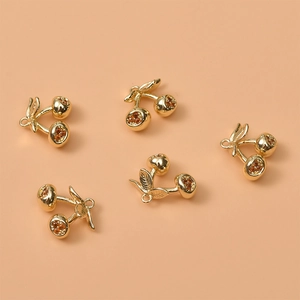 Detailed view of 14K gold plated cherry pendants with sparkling zircons for DIY jewelry