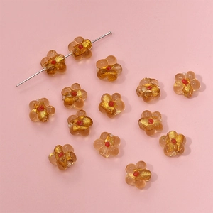 Macro detail of amber flower glass beads with gold leaf texture for DIY jewelry making