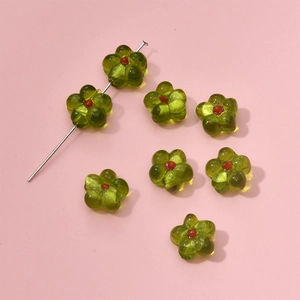 Macro shot of light green glass flower beads with red centers for DIY jewelry making