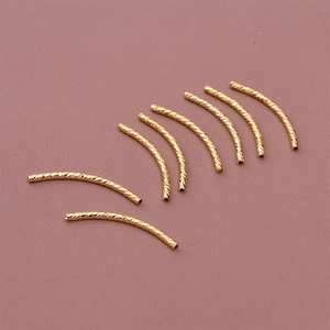 Detailed macro view of 18K gold-plated curved spacer beads with spiral texture for DIY jewelry