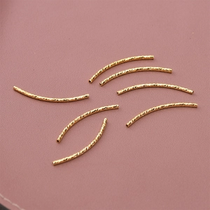 Macro shot of 18K gold-plated curved tubes with spiral texture for jewelry making