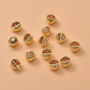 Detailed view of 14K gold plated pomegranate charms with red mini zircon stones