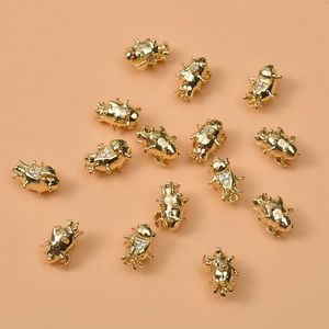 Macro detail of 14K gold plated insect charms with zircons for DIY jewelry making