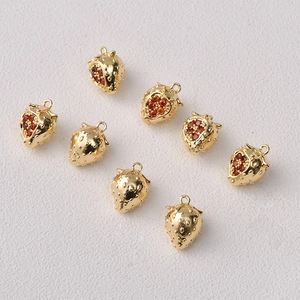 Detailed close-up of 14K gold-plated strawberry fruit charms with red micro-pave zircons