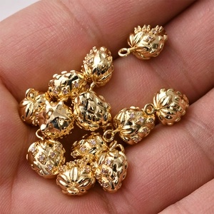 Macro view of a 14K gold-plated pineapple pendant featuring small pink gemstones