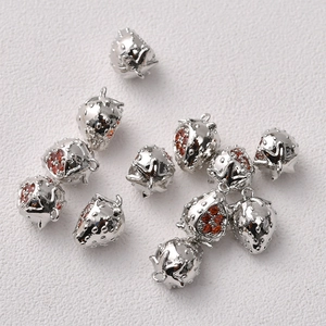 Macro detail of 14K gold plated strawberry pendants with red crystals for DIY jewelry making