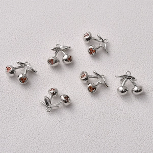 Macro shot of 14K gold plated cherry charms with red cubic zirconia for DIY jewelry