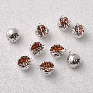 Detailed view of silver pomegranate charms with red cubic zirconia for DIY jewelry making