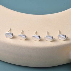 Macro detail of matte silver irregular pebble earrings with loops for DIY jewelry making