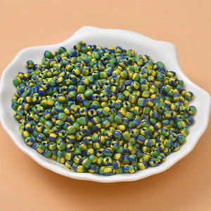 Detail of colorful striped glass seed beads for DIY jewelry in a white shell bowl