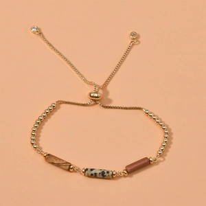 Adjustable gold bead bracelet featuring three rectangular synthetic stone cylinders