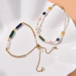 Detail of natural crystal cylinder beads and pearl bracelets with golden accents
