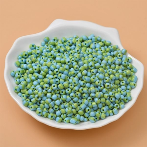 Close-up of candy color striped seed beads in a shell dish for DIY jewelry making