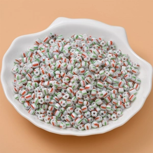 Macro shot of candy-colored striped seed beads for DIY jewelry making in a shell tray