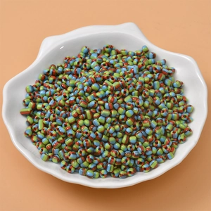 Detailed view of colorful striped glass seed beads for DIY jewelry in a shell tray