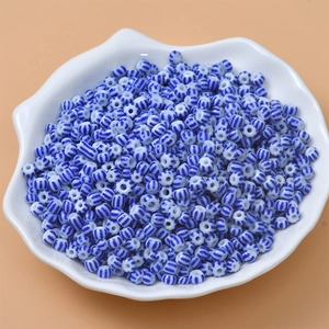 Macro detail of blue and white striped glass beads for DIY jewelry in a shell tray