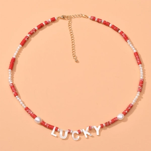 Detailed view of handmade beaded necklace featuring Lucky letter pearls and red stone beads