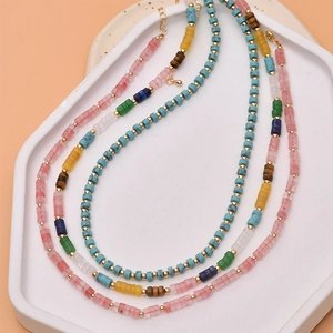 Close-up of bohemian tube bead necklace with colorful natural stones and gold spacers