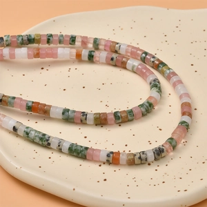 Colorful natural stone abacus beads arranged in a ceramic dish for DIY jewelry making