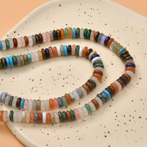 Close-up of mixed natural stone abacus beads on a ceramic tray for DIY jewelry making
