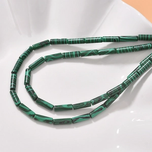 Detail of green malachite cylinder beads with black swirl patterns for jewelry making