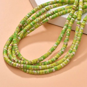 Detailed macro view of green marbled synthetic stone cylinder spacer beads for DIY jewelry