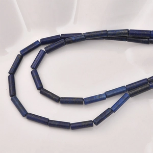 Detailed view of cylindrical lapis lazuli beads with natural blue and gold speckles