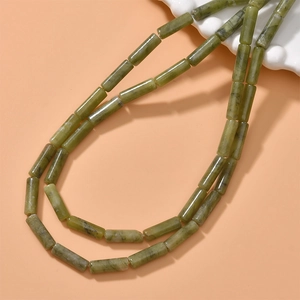 Detail of cylindrical green jade stone beads on a double-layer necklace with natural texture