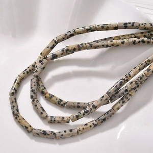 Macro shot of Dalmatian Jasper cylinder beads with black spots for DIY jewelry