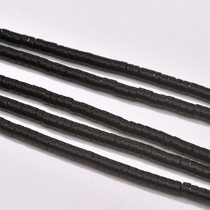 Detailed macro view of glossy black cylindrical beads for DIY retro jewelry making