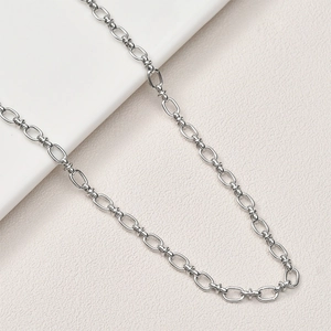Collier à gros maillons ovales argentés polis avec détails texturés sur fond blanc