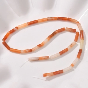 Macro view of cylindrical orange agate stone tube beads for DIY jewelry making