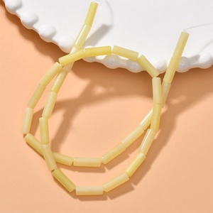 Detailed view of translucent pale yellow cylindrical beads for DIY jewelry making