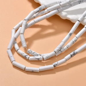 Macro detail of white howlite cylinder tube beads with natural grey marble textures