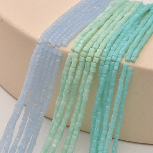 Close-up of 2mm square matte glass beads in light blue and mint green for DIY jewelry