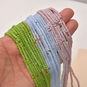 Detailed view of 2mm square glass crystal beads in green, blue, and purple for DIY jewelry