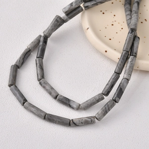 Macro detail of cylindrical marble beads with grey patterns for jewelry making
