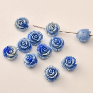 Detail of blue resin rose beads with marble texture and hole for jewelry DIY crafts