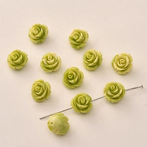 Detail of 12mm light green resin rose beads showing the vertical hole for DIY jewelry