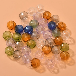 Macro view of multi-faceted hollow glass beads in various colors for DIY jewelry making