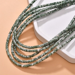 Detailed close-up of natural green and white stone cylinder beads for DIY jewelry making